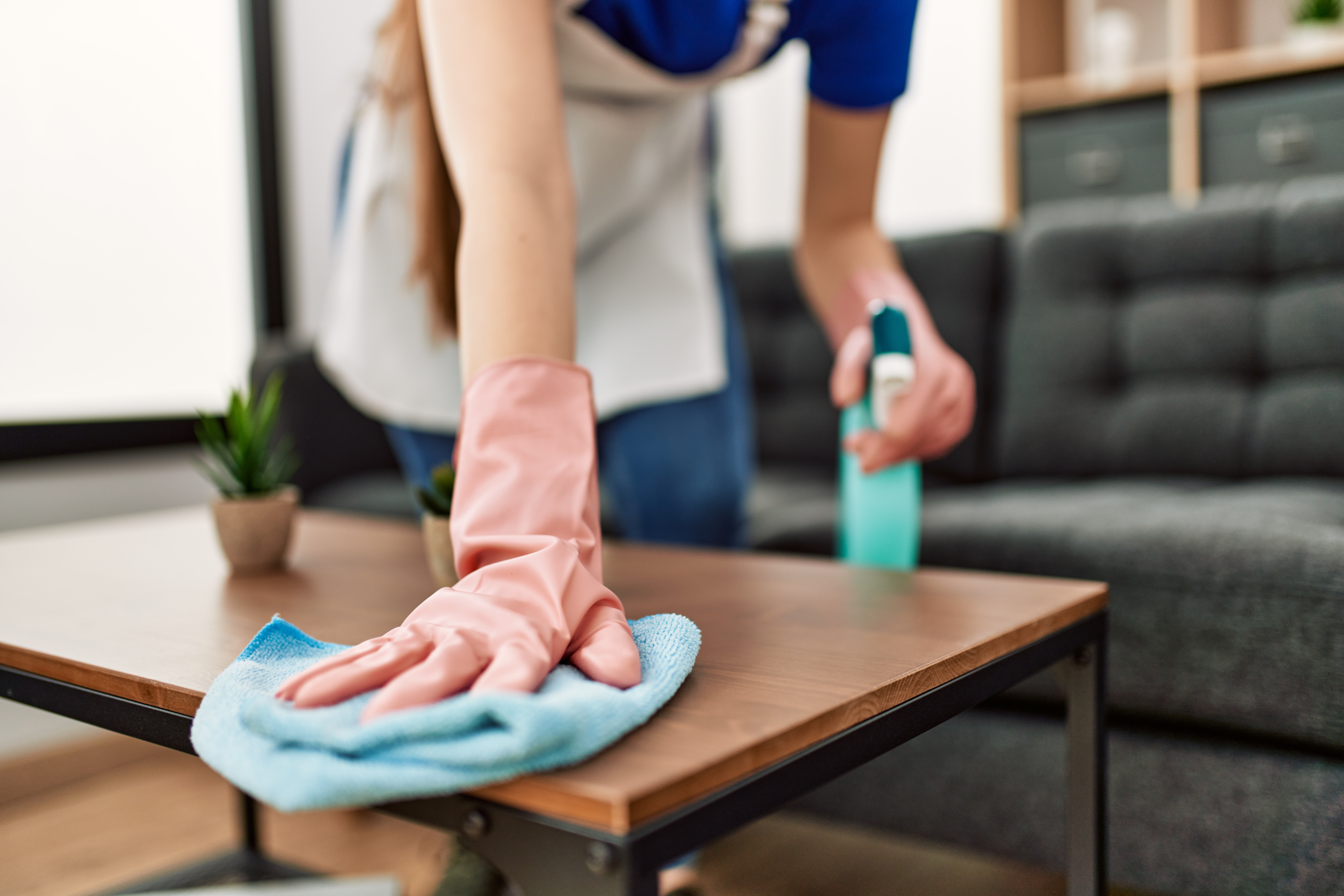A cleaner wiping down a table during a home cleaning in Indiana